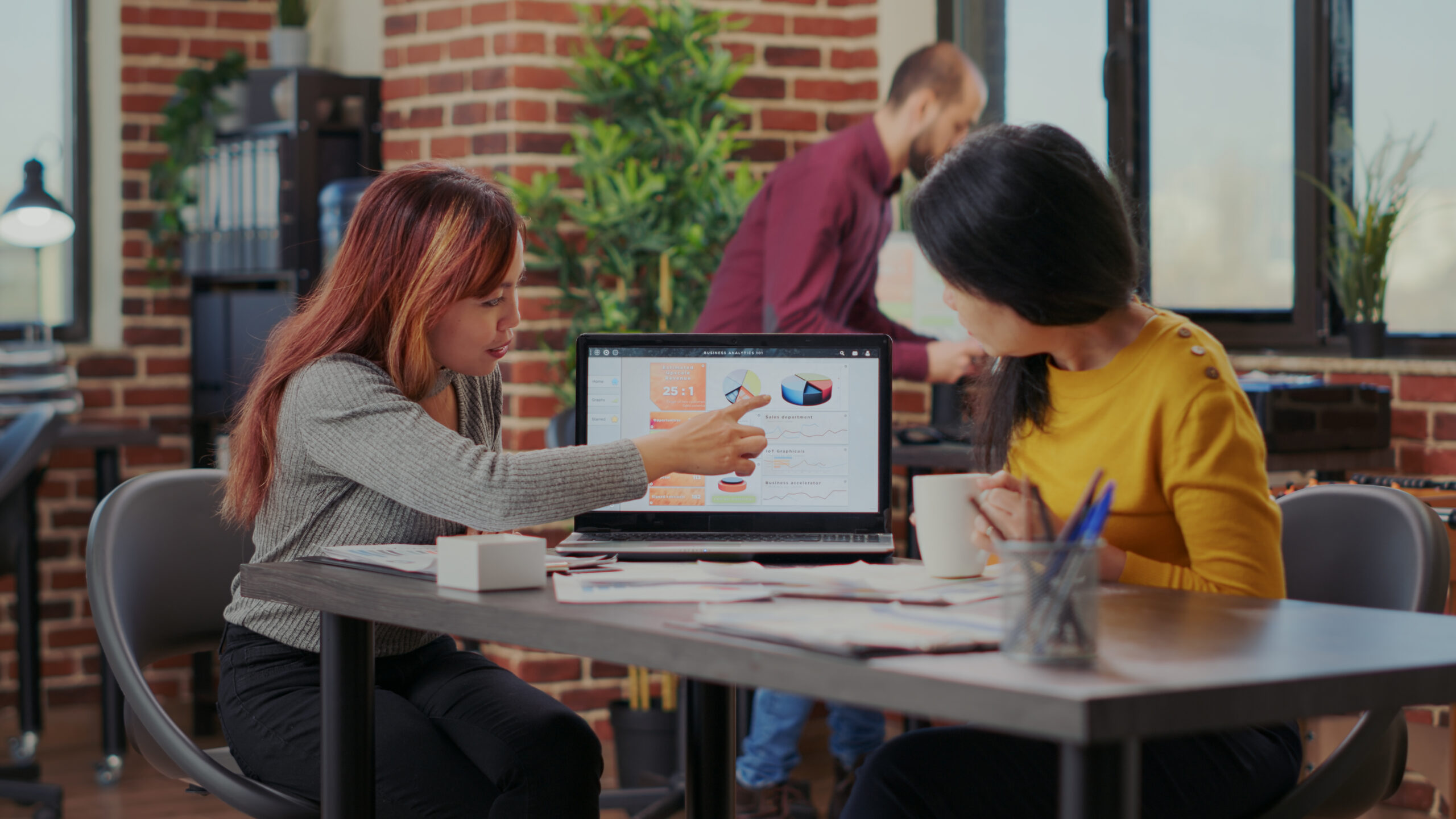Business people examining statistics on laptop to do research